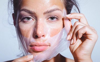 Close-up beauty portrait of a beautiful, natural young woman removing face mask. Copy space has been left